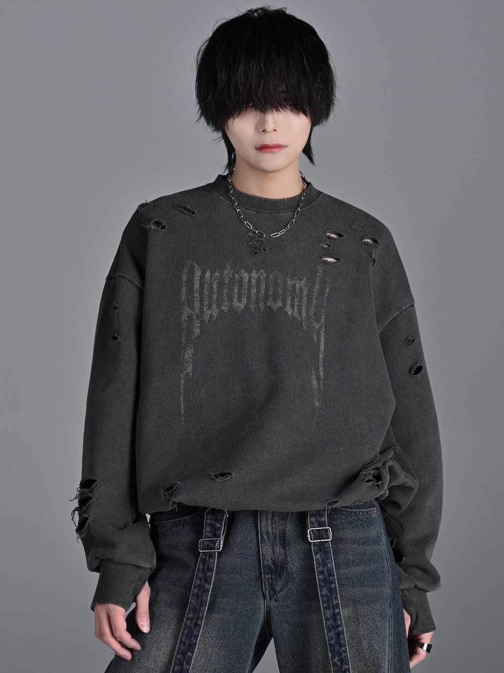 ブラック系のスニーカー、ブルー系のデニムパンツ、グレー系のスウェットを着用したメンズの冬コーディネートの3枚目の写真