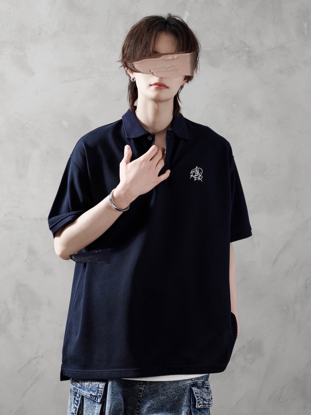 ホワイト系のタンクトップ、ブルー系のカーゴパンツ、ブラック系のブーツを着用したメンズの春コーディネートの2枚目の写真