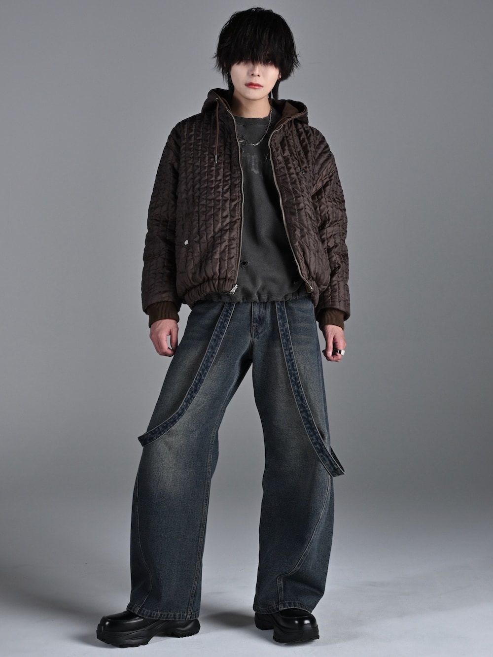 ブラック系のスニーカー、ブラウン系のブルゾン、グレー系のスウェットを着用したメンズの冬コーディネートの3枚目の写真