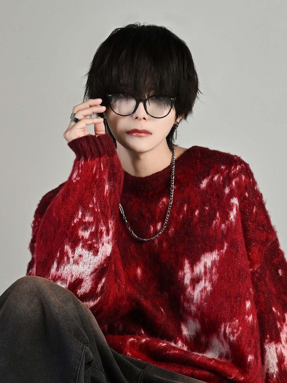 ブラック系のスニーカー、レッド系のニット/セーター、ブラック系のデニムパンツを着用したメンズの秋コーディネートの3枚目の写真