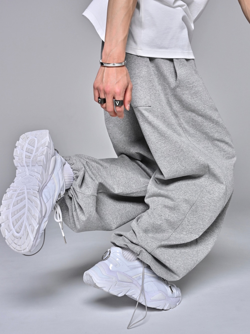 ホワイト系のタンクトップ、ホワイト系のスニーカー、グレー系のスウェットパンツを着用したメンズの夏コーディネートの4枚目の写真