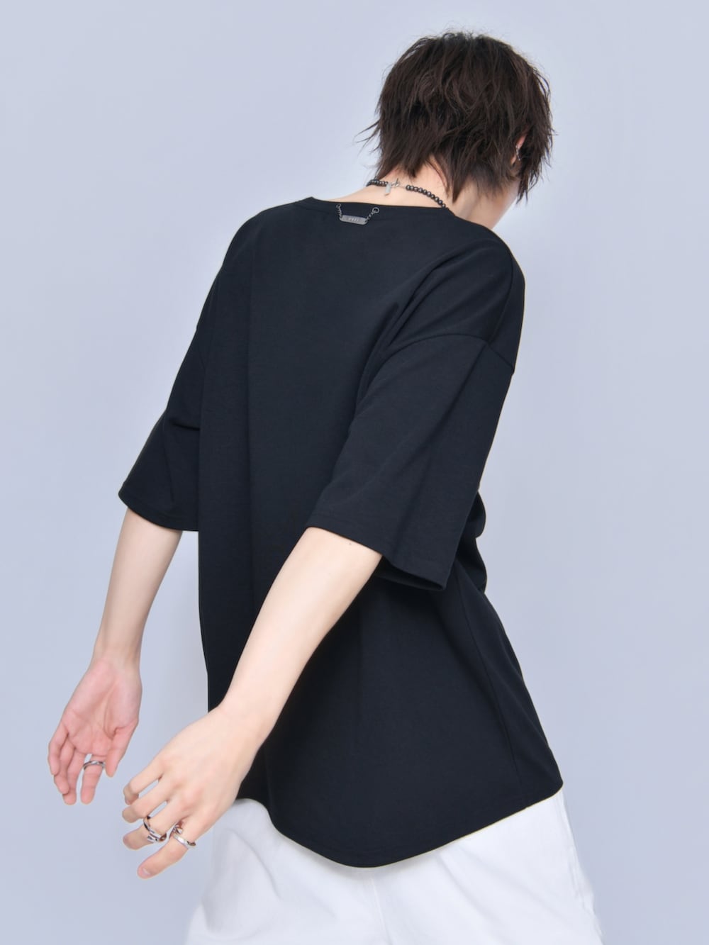 ホワイト系のデニムパンツ、ブラック系のサンダル、ブラック系のTシャツ/カットソーを着用したメンズの春コーディネートの4枚目の写真