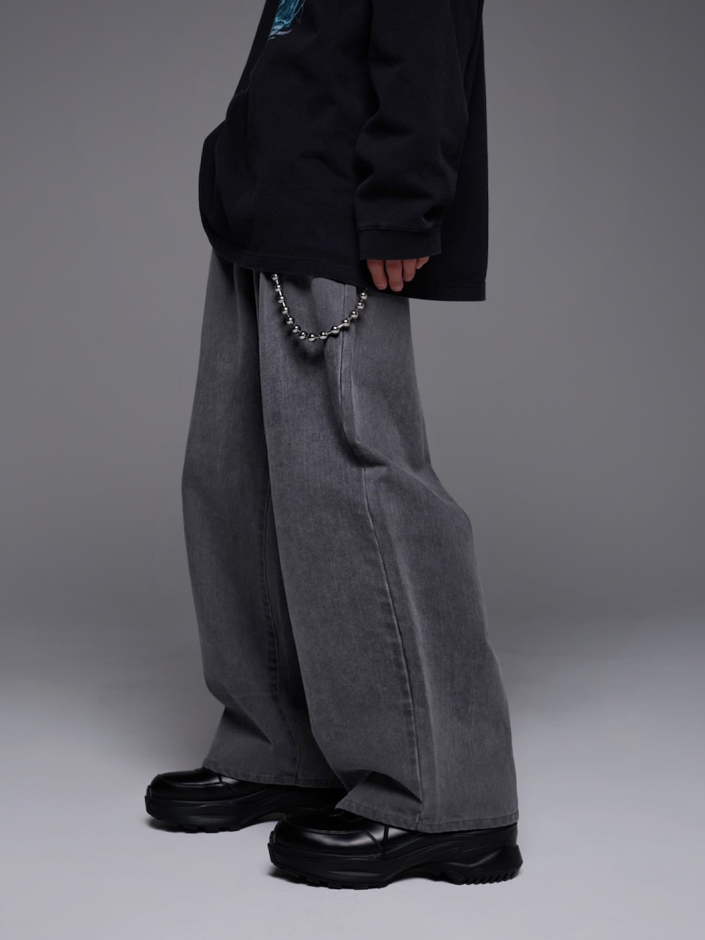 ブラック系のTシャツ/カットソー、ブルー系のデニムパンツ、ブラック系のスニーカーを着用したメンズの冬コーディネートの4枚目の写真