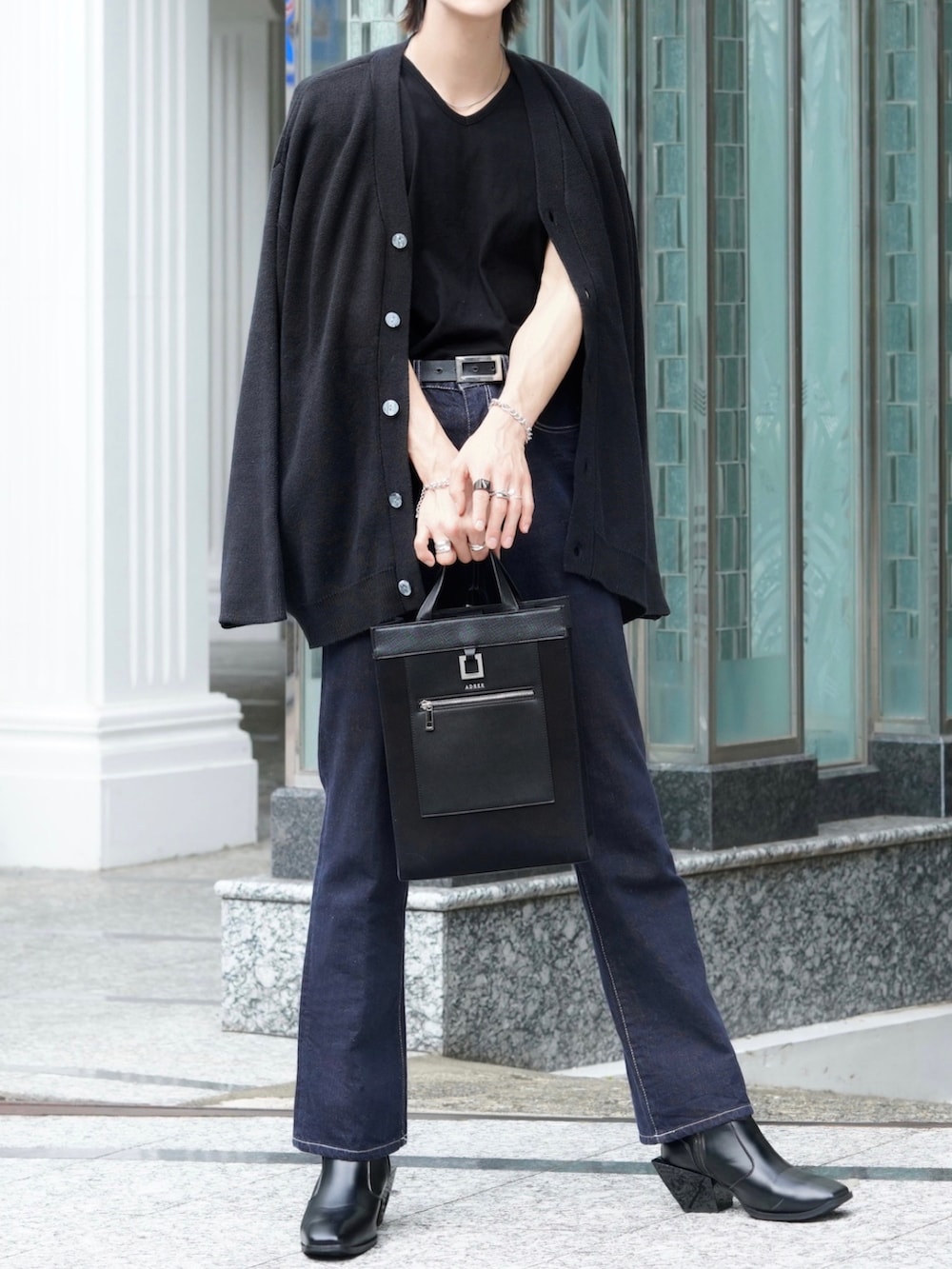 ブラック系のTシャツ/カットソー、ブルー系のデニムパンツ、ブラック系のブーツを着用したメンズの秋コーディネートの2枚目の写真