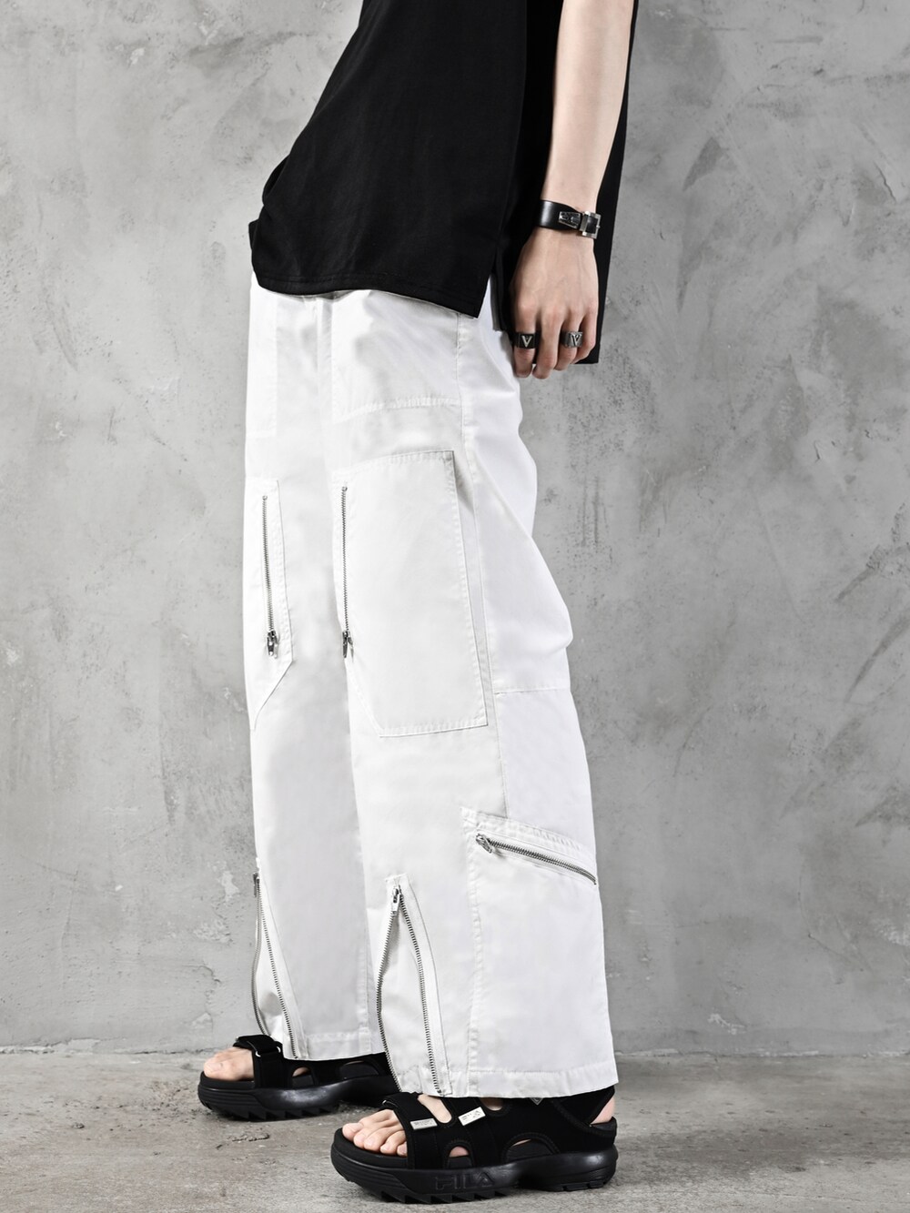 ブラック系のタンクトップ、ホワイト系のデニムパンツ、ブラック系のショルダーバッグを着用したメンズの春コーディネートの5枚目の写真