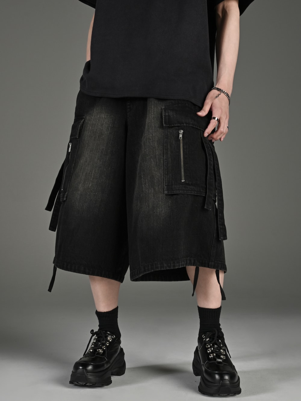 ホワイト系のスニーカー、ブラック系のTシャツ/カットソー、ブラック系のカーゴパンツを着用したメンズの春コーディネートの2枚目の写真