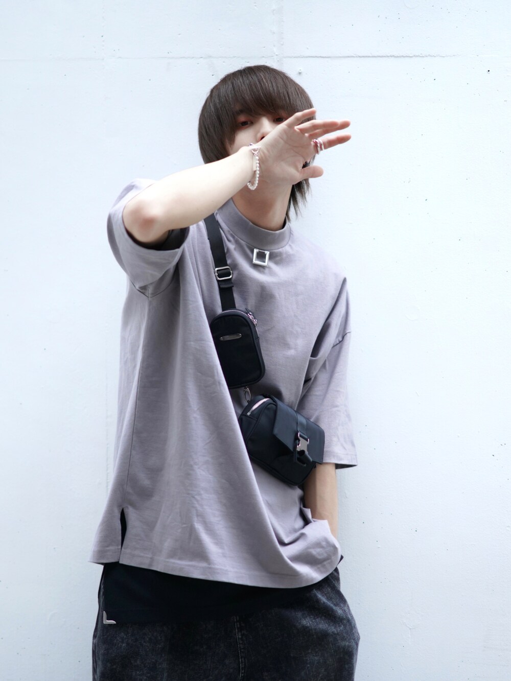 ブラック系のデニムパンツ、ブラック系のスニーカー、ブラック系のショルダーバッグを着用したメンズの春コーディネートの4枚目の写真