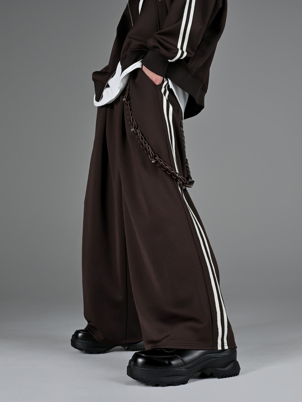 ブラック系のスニーカー、グレー系のタンクトップ、ブラウン系のブルゾンを着用したメンズの冬コーディネートの3枚目の写真