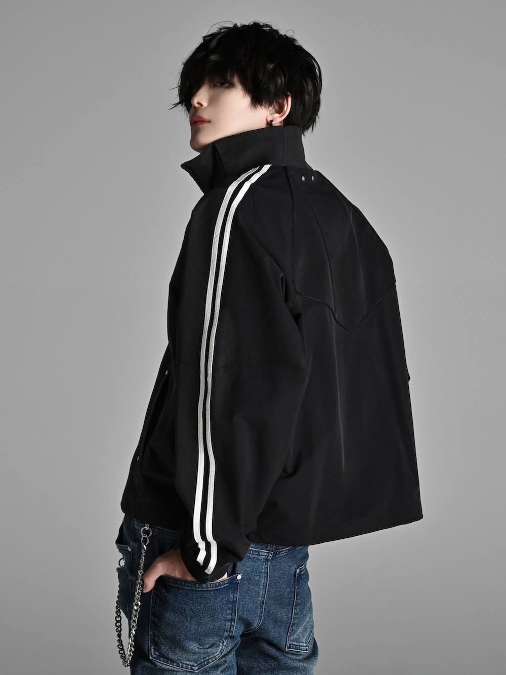 ブラック系のスニーカー、ブラック系のショルダーバッグ、ブラック系のナイロンジャケットを着用したメンズの冬コーディネートの3枚目の写真