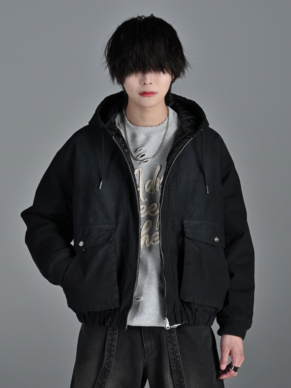 ホワイト系のスニーカー、ブラック系のブルゾン、グレー系のスウェットを着用したメンズの冬コーディネートの4枚目の写真