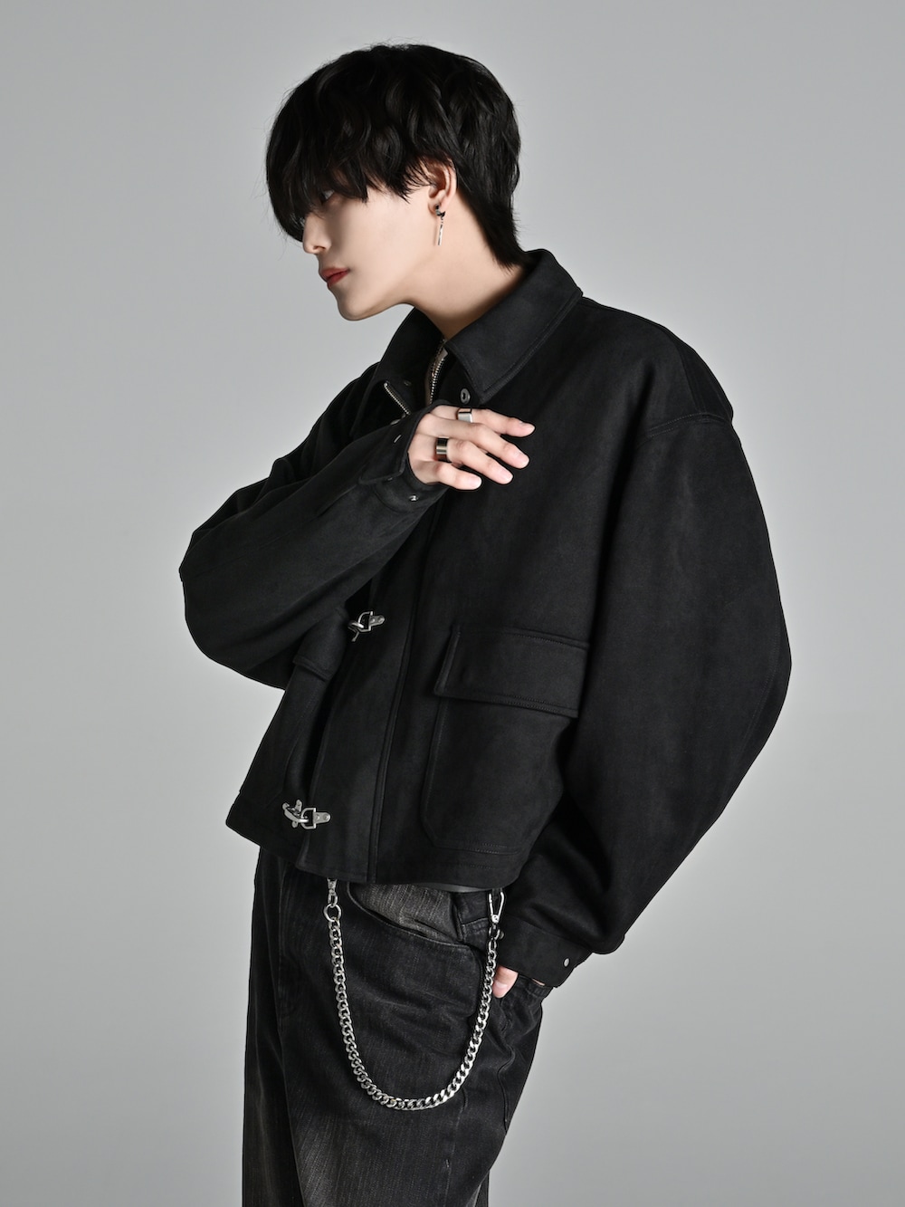 ブラック系のデニムパンツ、ブラック系のブーツ、ブラック系のショルダーバッグを着用したメンズの冬コーディネートの3枚目の写真