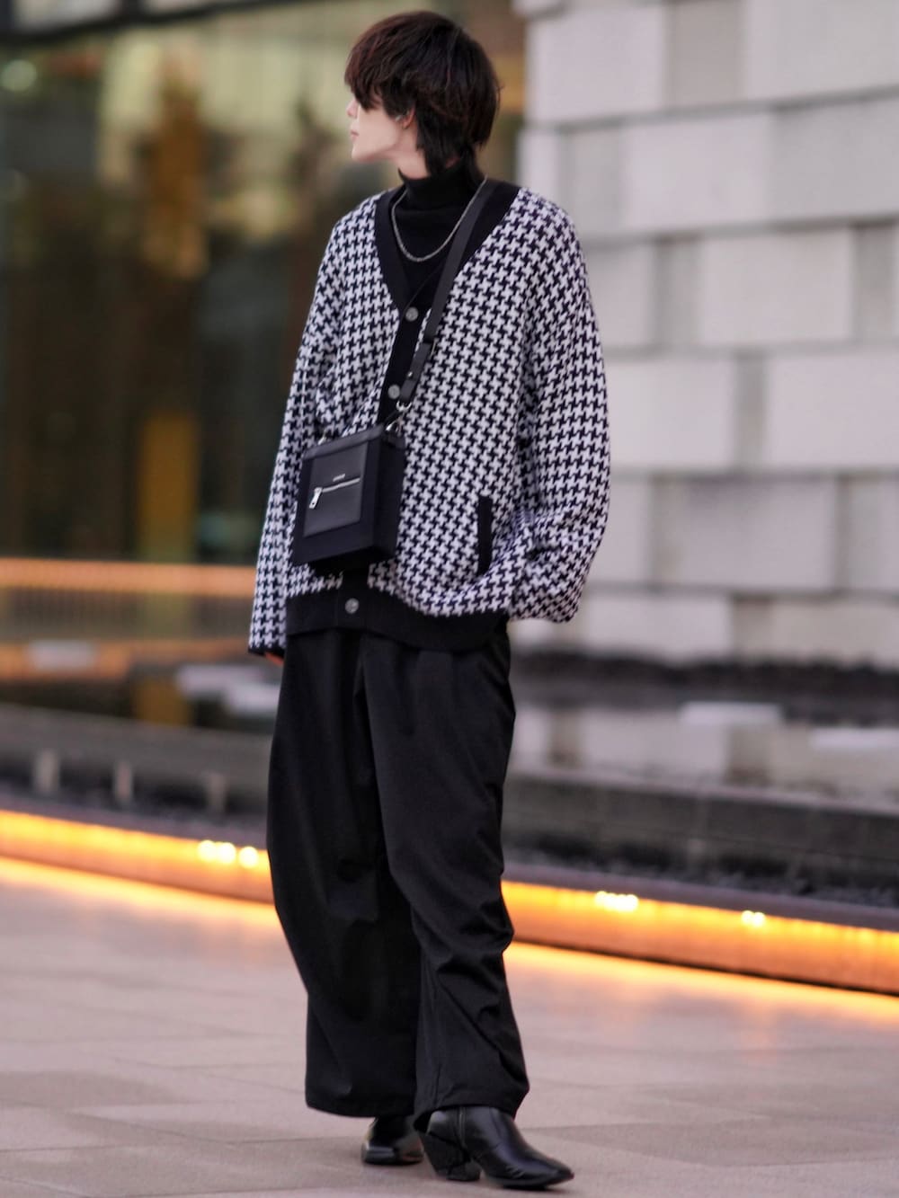 ブラック系のニット/セーター、ブラック系のブーツ、ブラック系のカーゴパンツを着用したメンズの冬コーディネートの2枚目の写真