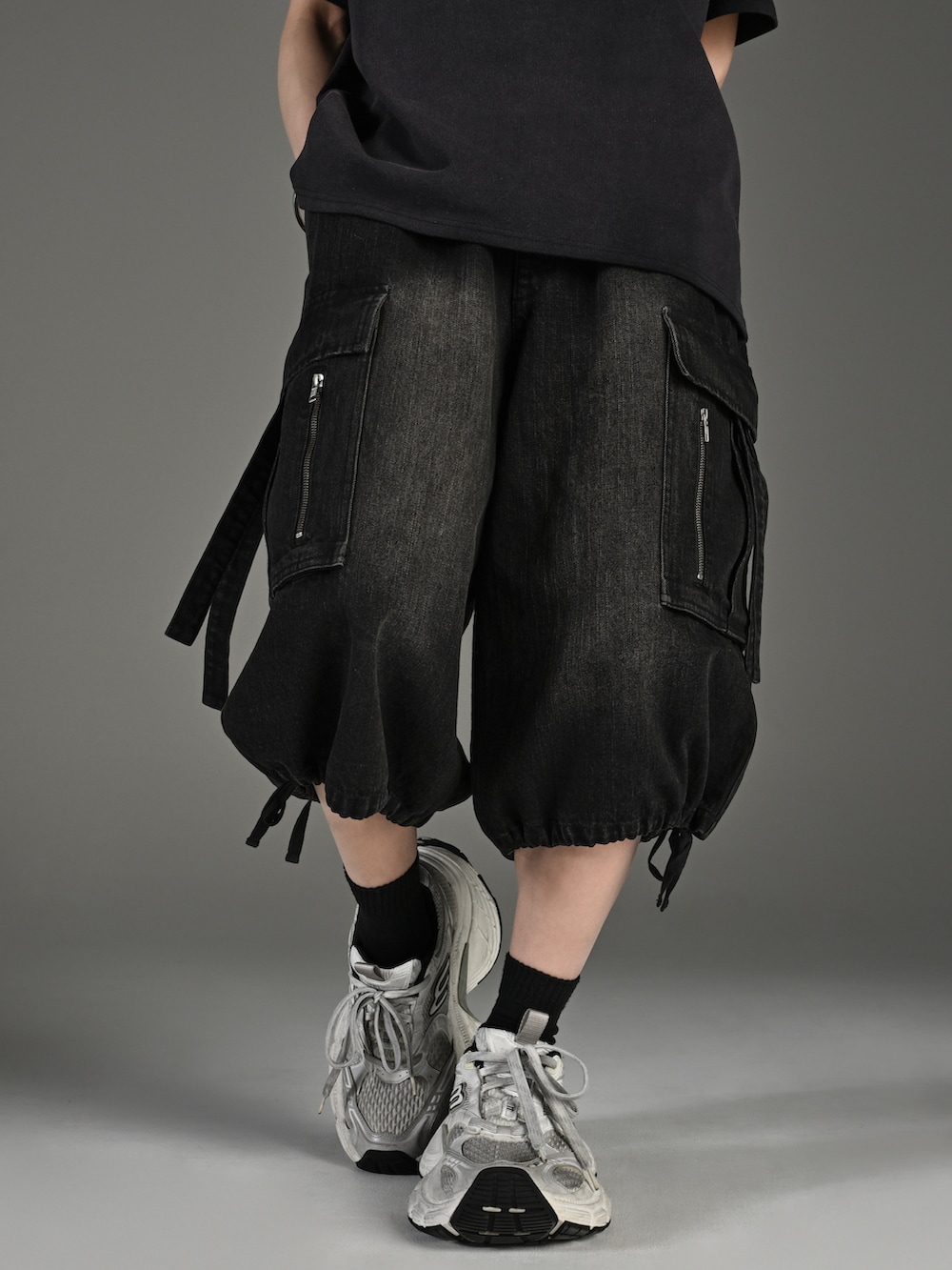 ホワイト系のスニーカー、ブラック系のTシャツ/カットソー、ブラック系のカーゴパンツを着用したメンズの春コーディネートの4枚目の写真