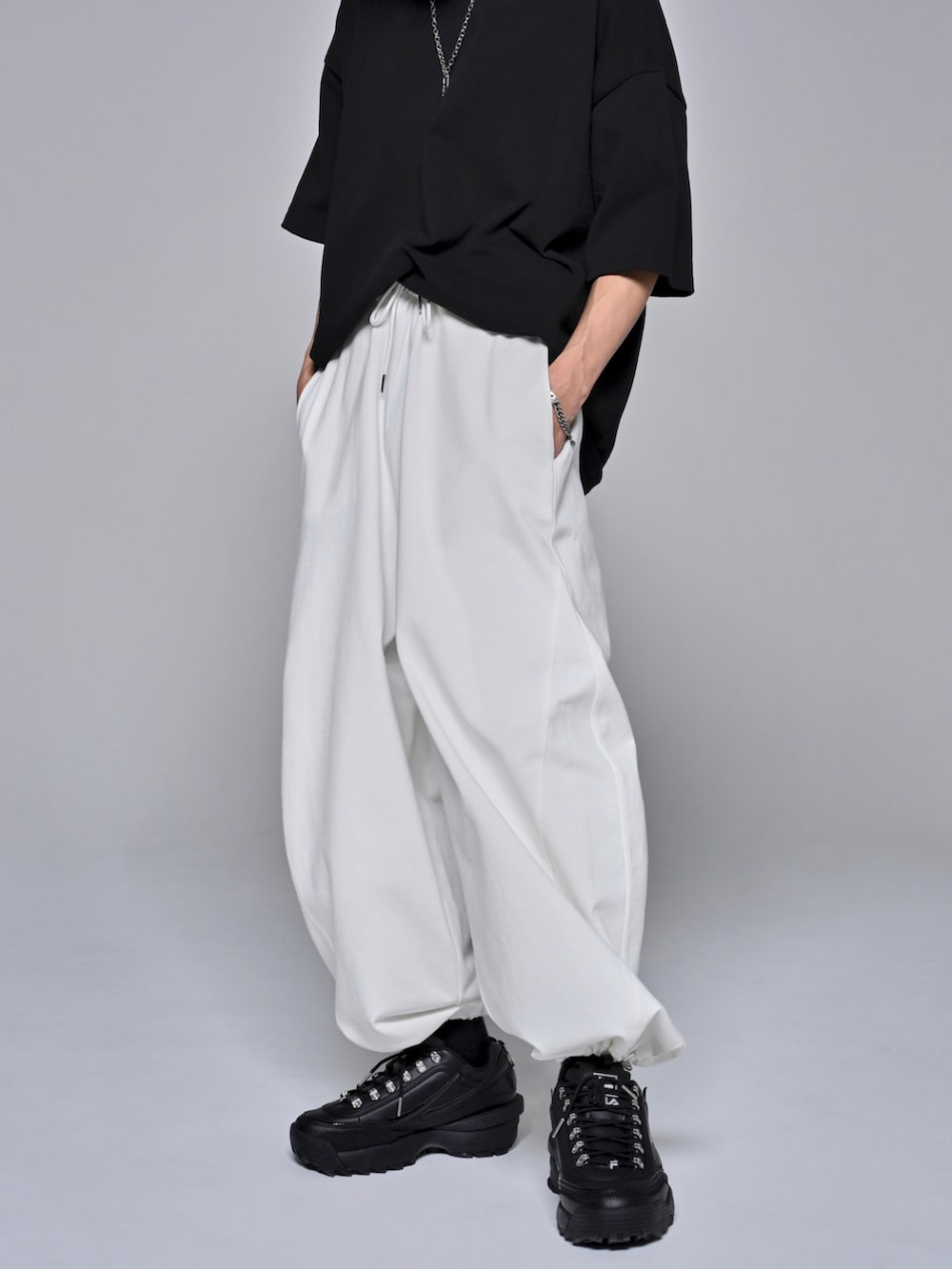 ブラック系のTシャツ/カットソー、ブラック系のスニーカー、ホワイト系のスウェットパンツを着用したメンズの夏コーディネートの2枚目の写真