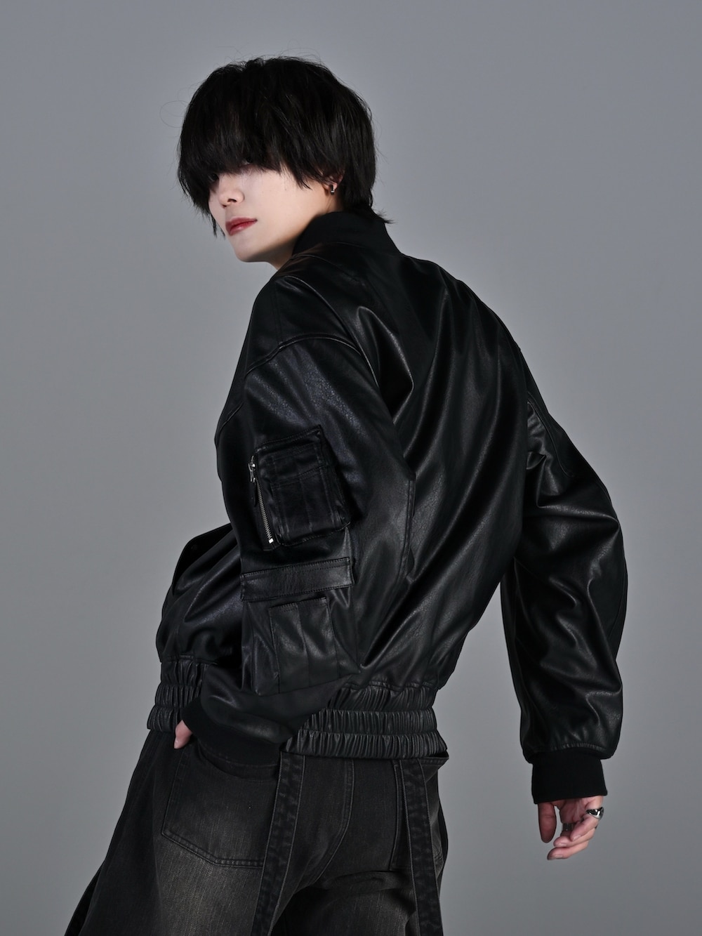 ブラック系のデニムパンツ、ブラック系のブーツ、レッド系のタンクトップを着用したメンズの冬コーディネートの5枚目の写真