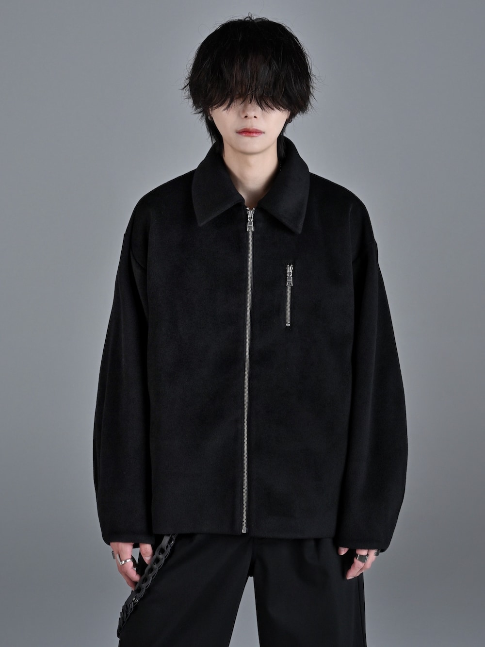 ブラック系のタンクトップ、ブラック系のスラックス、ホワイト系のスニーカーを着用したメンズの秋コーディネートの4枚目の写真