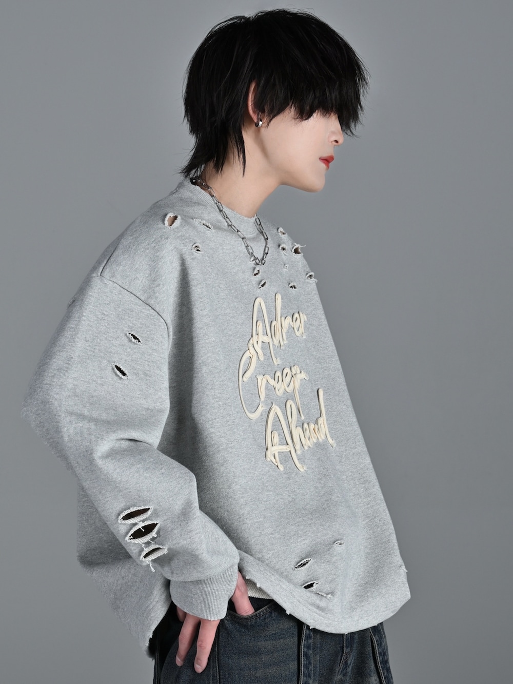 グレー系のスウェット、ブルー系のデニムパンツ、ホワイト系のスニーカーを着用したメンズの冬コーディネートの4枚目の写真