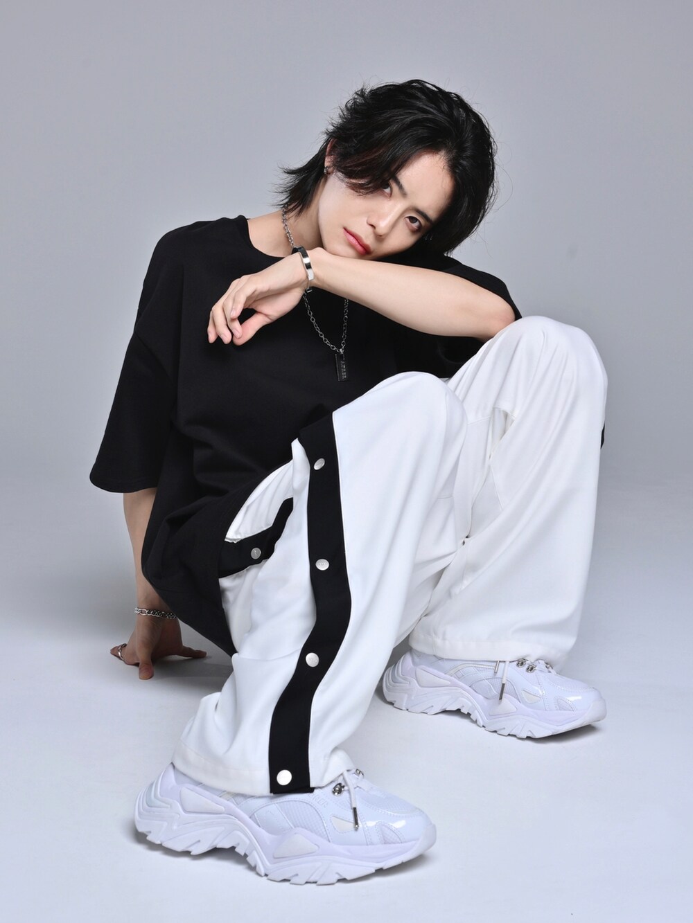 ブラック系のTシャツ/カットソー、ホワイト系のスニーカー、ホワイト系のその他パンツを着用したメンズの春コーディネートの2枚目の写真