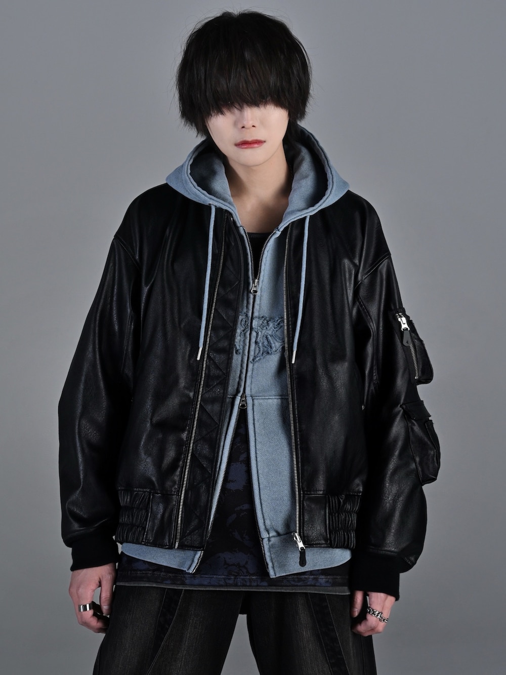 ブラック系のデニムパンツ、ブラック系のブーツ、レッド系のタンクトップを着用したメンズの冬コーディネートの2枚目の写真