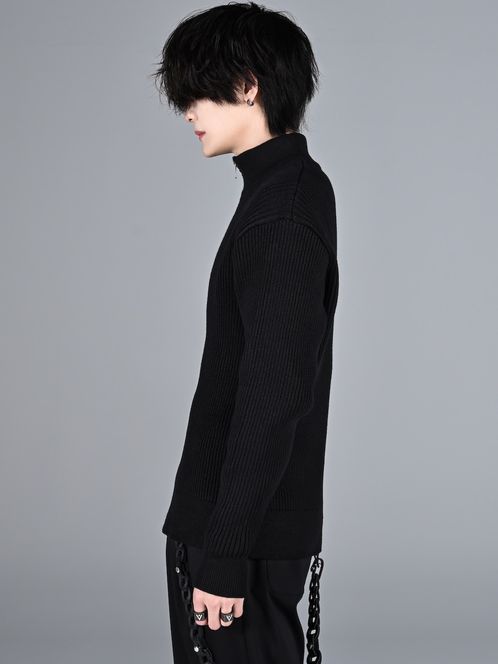 ブラック系のスラックス、ブラック系のブーツ、ブラック系のニット/セーターを着用したメンズの冬コーディネートの4枚目の写真