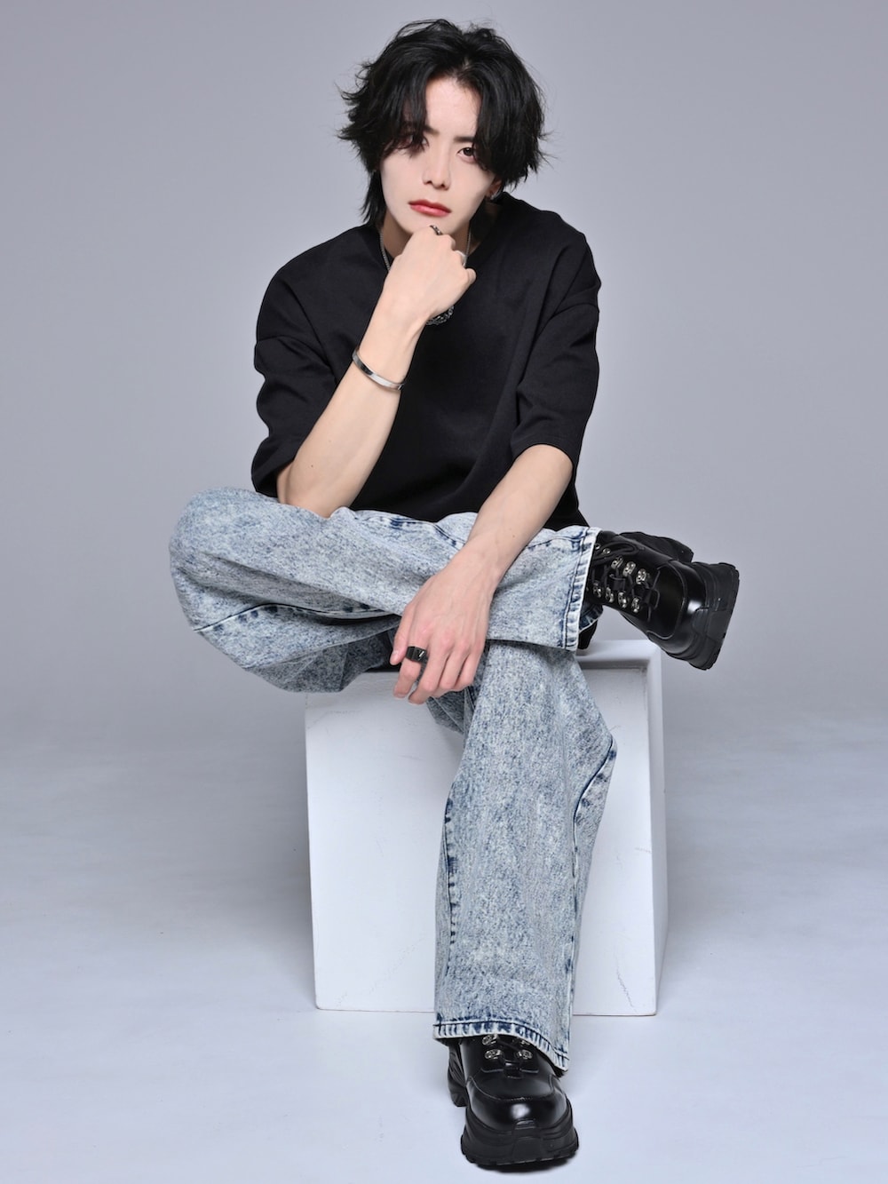 ブルー系のデニムパンツ、ブラック系のスニーカー、ブラック系のTシャツ/カットソーを着用したメンズの春コーディネートの2枚目の写真