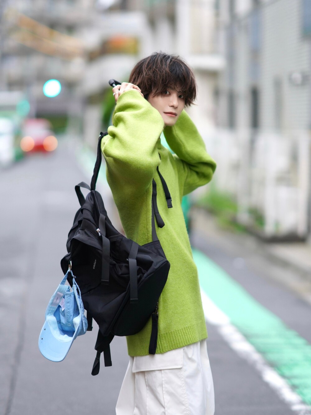 ホワイト系のカーゴパンツ、ブラック系のバックパック/リュック、グリーン系のニット/セーターを着用したメンズの秋コーディネートの3枚目の写真