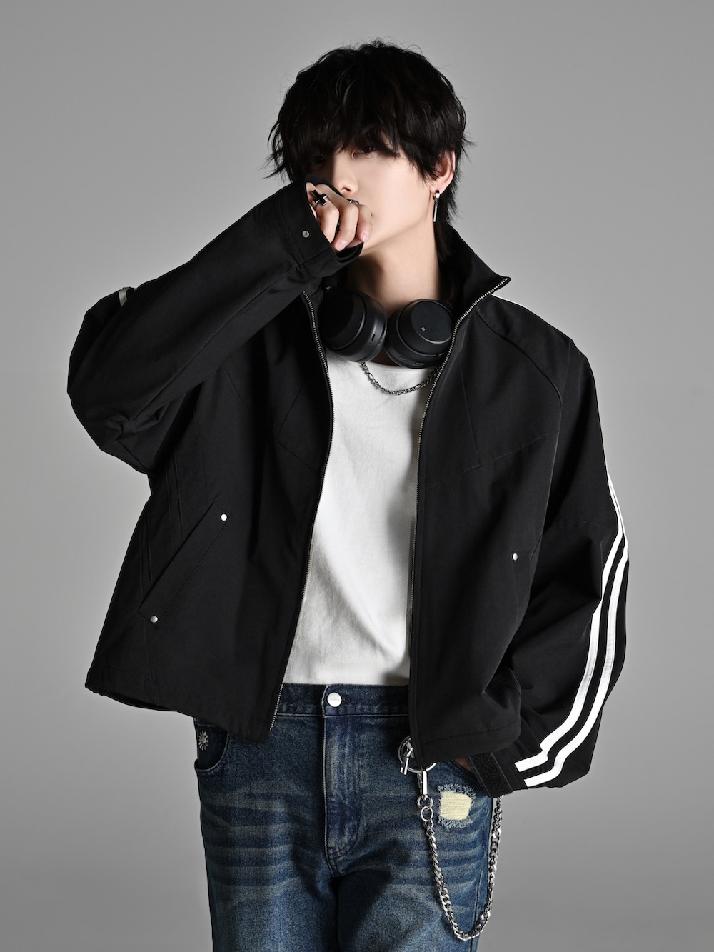 ブラック系のスニーカー、ブラック系のショルダーバッグ、ブラック系のナイロンジャケットを着用したメンズの冬コーディネートの2枚目の写真