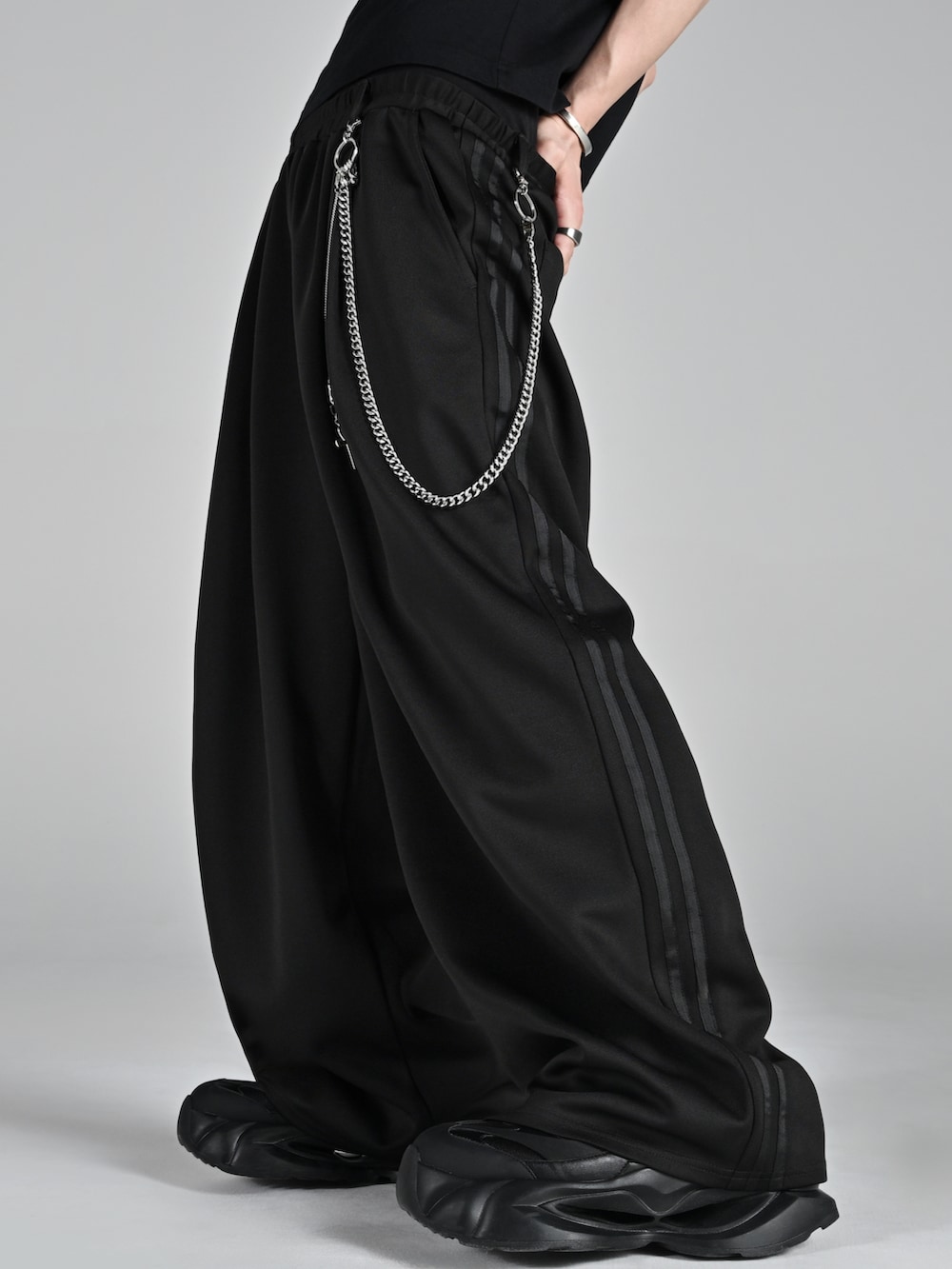 ブラック系のスニーカー、ブラック系のスウェット、ブラック系のその他パンツを着用したメンズの冬コーディネートの2枚目の写真