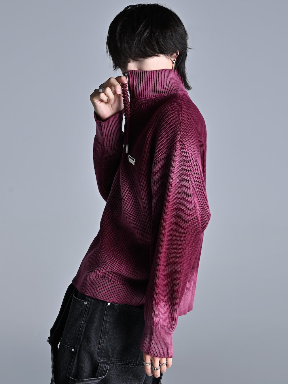 レッド系のニット/セーター、ブラック系のデニムパンツ、ブラック系のスニーカーを着用したメンズの秋コーディネートの4枚目の写真