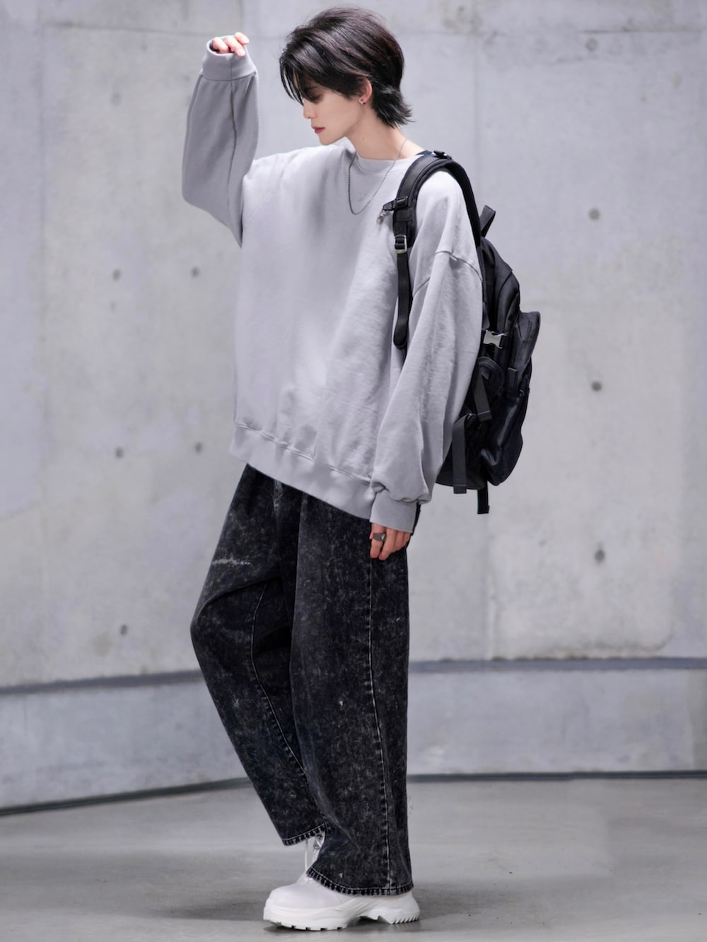 ブラック系のデニムパンツ、ホワイト系のスニーカー、ブラック系のバックパック/リュックを着用したメンズの冬コーディネートの3枚目の写真