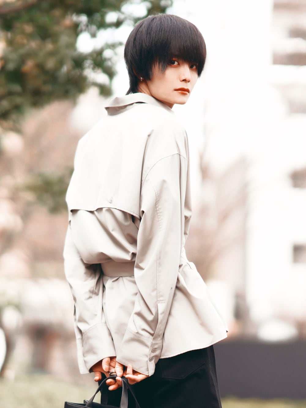 ホワイト系のテーラードジャケット、ブラック系のデニムパンツ、ブラック系のブーツを着用したメンズの春コーディネートの5枚目の写真