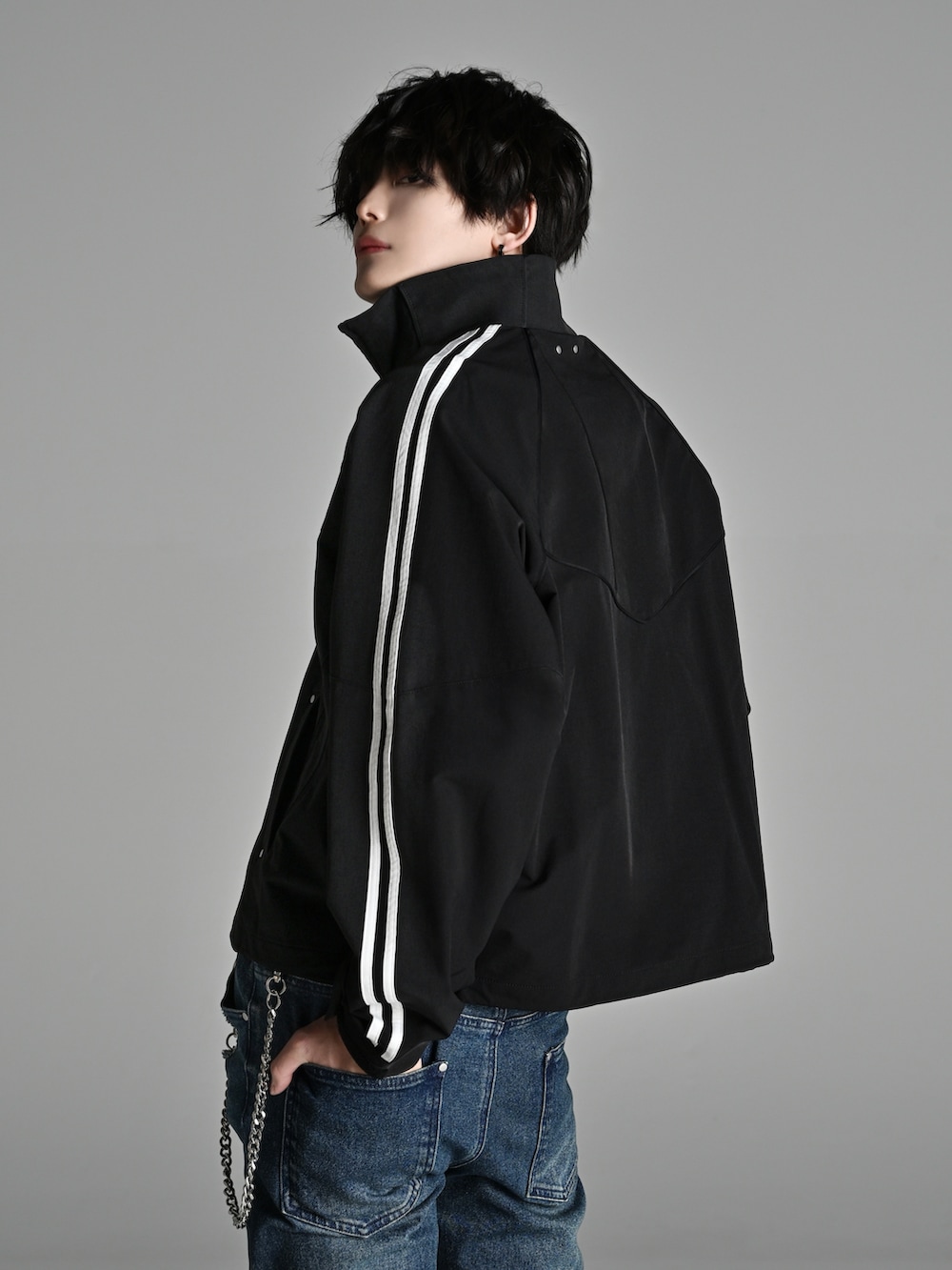 ブラック系のスニーカー、ブラック系のショルダーバッグ、ブラック系のナイロンジャケットを着用したメンズの冬コーディネートの3枚目の写真