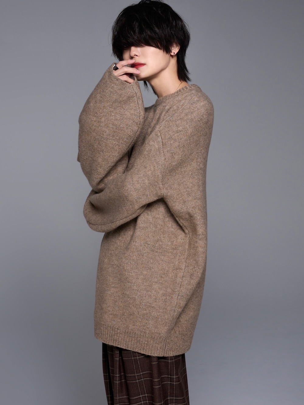 ブラウン系のスラックス、ブラック系のスニーカー、ベージュ系のニット/セーターを着用したメンズの秋コーディネートの5枚目の写真