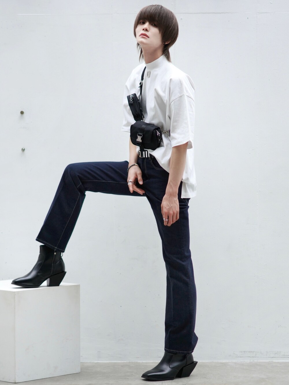 ブラック系のテーラードジャケット、ブルー系のデニムパンツ、ブラック系のブーツを着用したメンズの春コーディネートの3枚目の写真