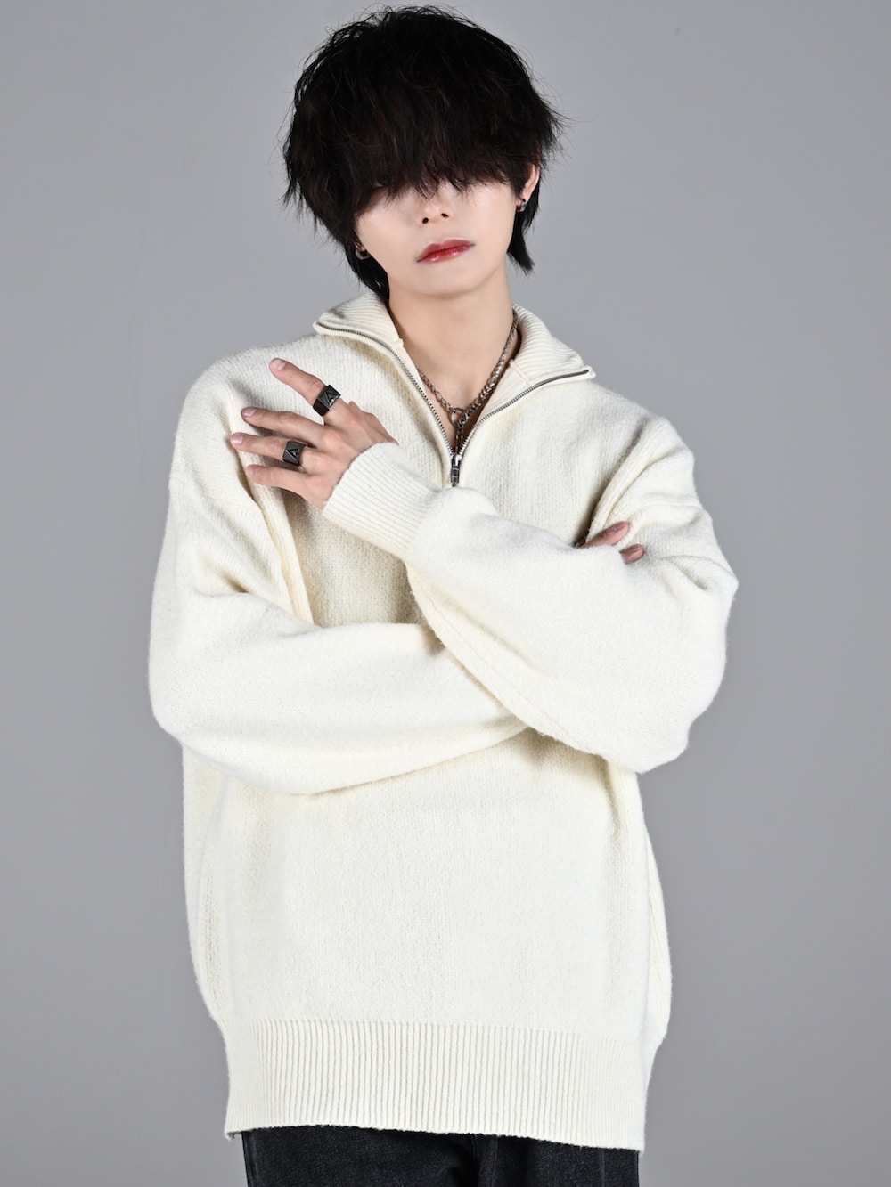 ホワイト系のスニーカー、ホワイト系のニット/セーター、ブラック系のデニムパンツを着用したメンズの秋コーディネートの3枚目の写真