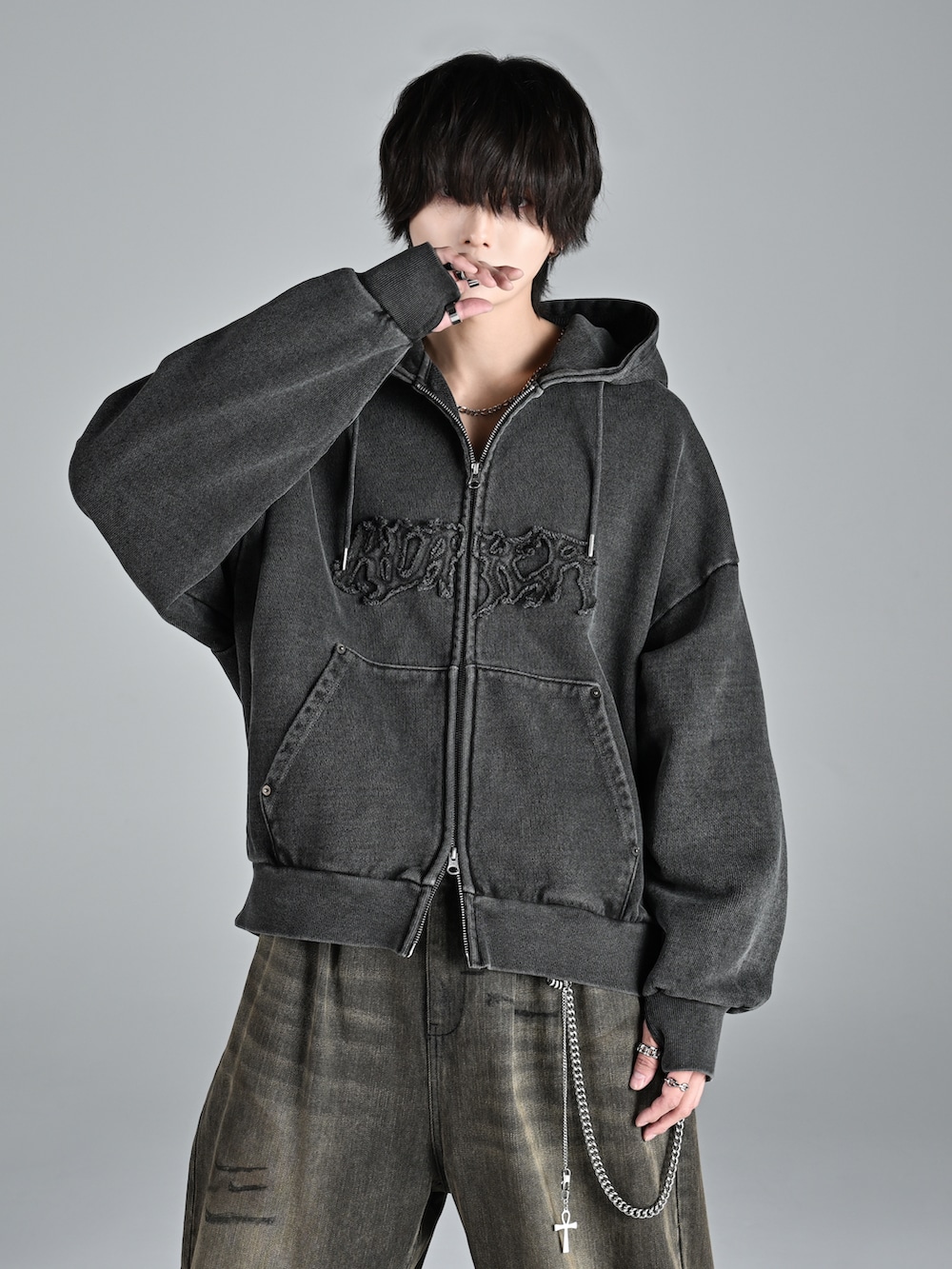 レッド系のタンクトップ、グレー系のパーカー、ブルー系のデニムパンツを着用したメンズの秋コーディネートの2枚目の写真