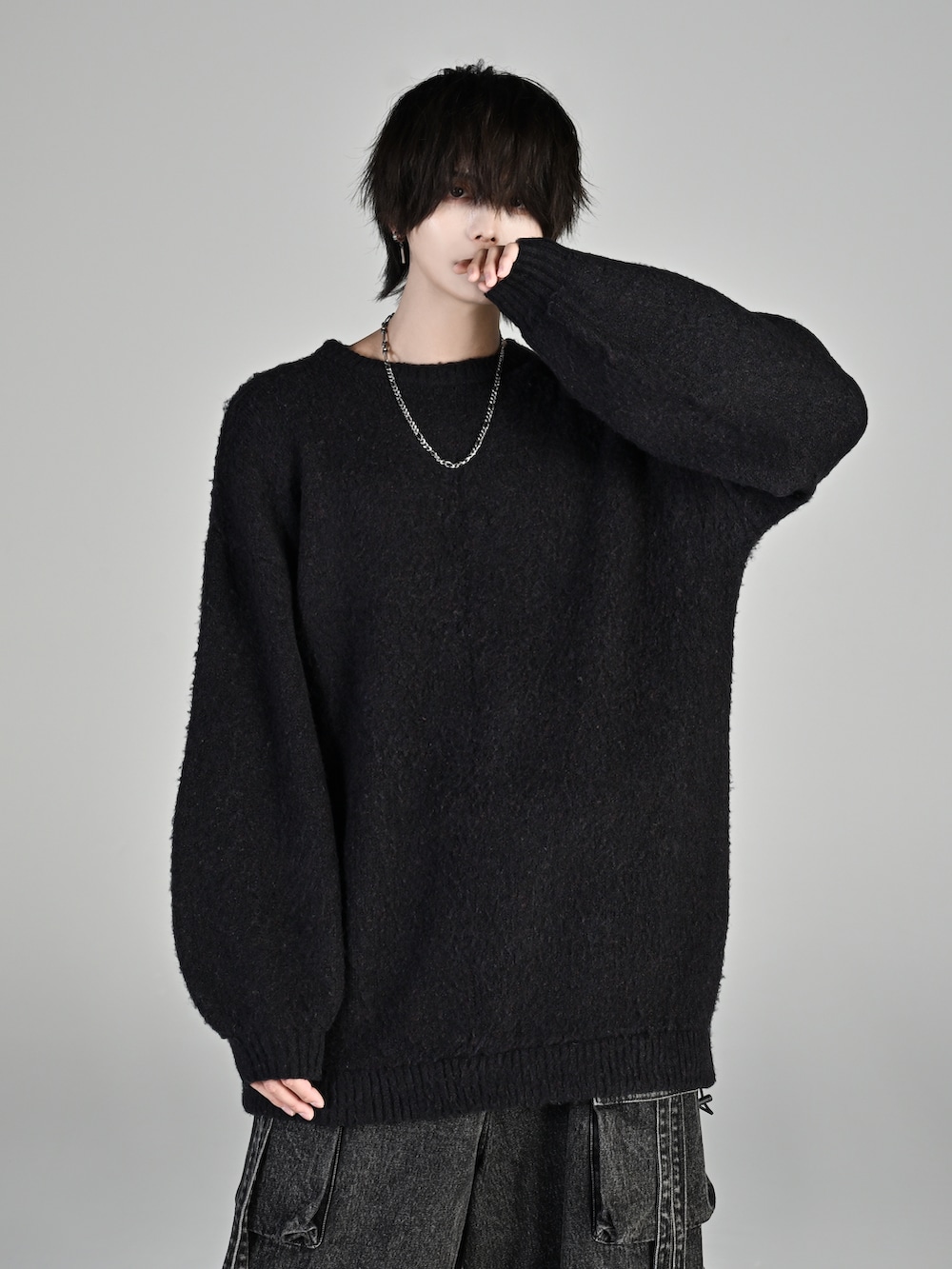 ブラック系のカーゴパンツ、ブラック系のローファー、ブラック系のニット/セーターを着用したメンズの秋コーディネートの2枚目の写真