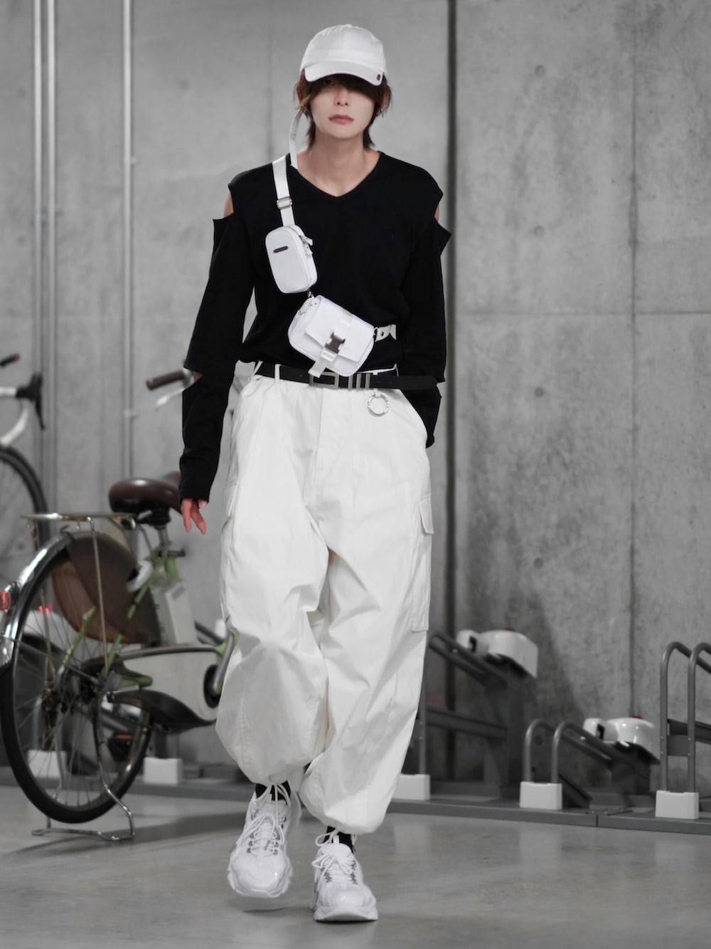 ホワイト系のカーゴパンツ、ホワイト系のショルダーバッグ、ブラック系のTシャツ/カットソーを着用したメンズの秋コーディネートの2枚目の写真