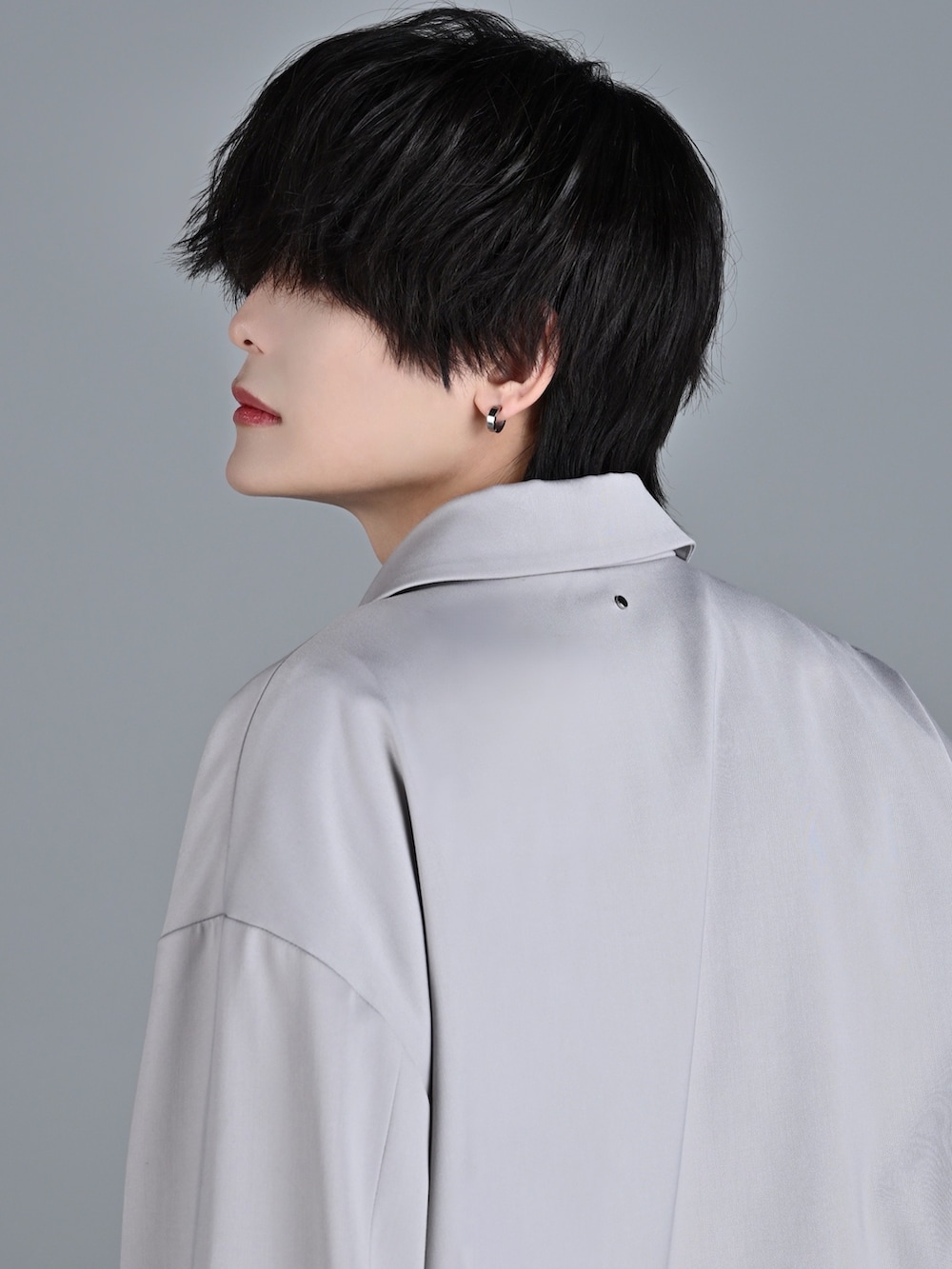 ブルー系のデニムパンツ、レッド系のタンクトップ、グレー系のテーラードジャケットを着用したメンズの冬コーディネートの5枚目の写真