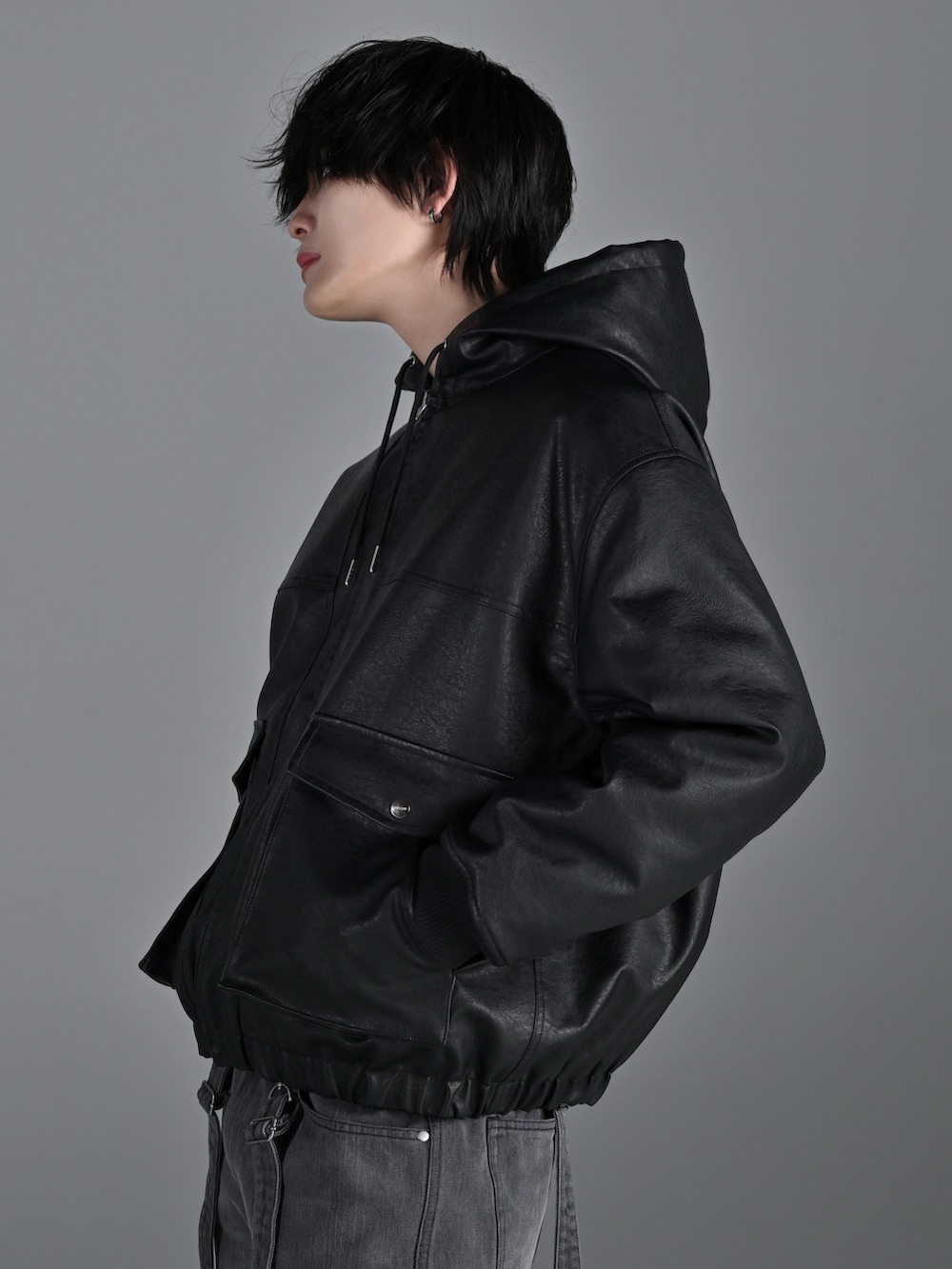 ブラック系のブルゾン、グレー系のスウェット、グレー系のデニムパンツを着用したメンズの冬コーディネートの3枚目の写真