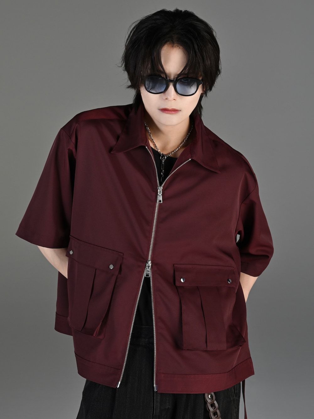 ブラック系のデニムパンツ、ブラック系のブーツ、レッド系のタンクトップを着用したメンズの春コーディネートの4枚目の写真