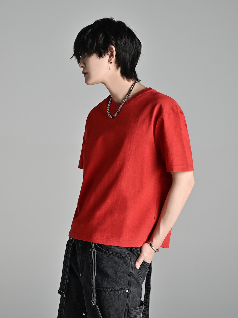 ブルー系のデニムパンツ、レッド系のTシャツ/カットソー、ブラウン系のブーツを着用したメンズの春コーディネートの3枚目の写真