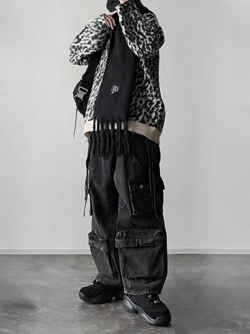 ブラウン系のステンカラーコート、ブラック系のリング、シルバー系のピアス（両耳用）を着用したメンズの冬コーディネートの2枚目の写真