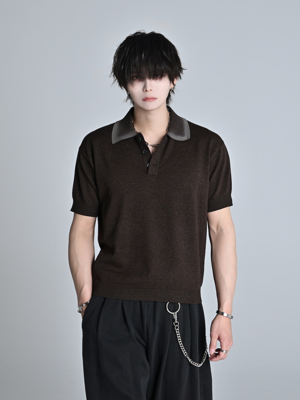 ブラウン系のポロシャツ、ブラック系のデニムパンツ、ブラック系のショルダーバッグを着用したメンズの春コーディネートの2枚目の写真