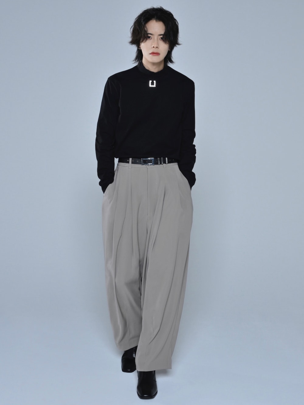 ブラック系のブーツ、ブラック系のTシャツ/カットソー、ベージュ系のテーラードジャケットを着用したメンズの冬コーディネートの3枚目の写真