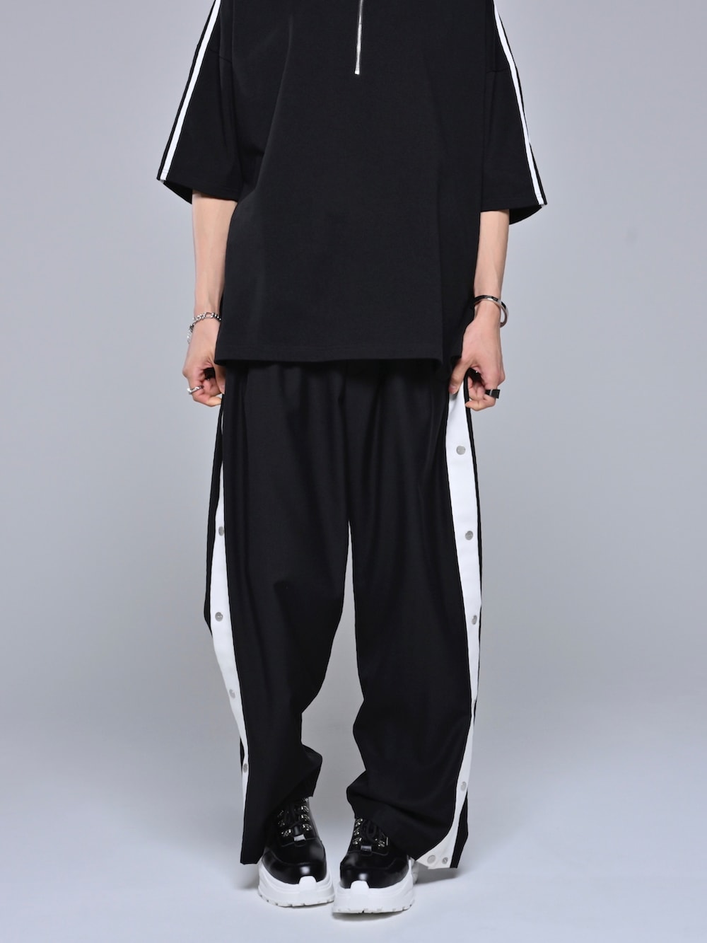 ブラック系のスニーカー、ブラック系のその他パンツ、ブラック系のTシャツ/カットソーを着用したメンズの春コーディネートの4枚目の写真