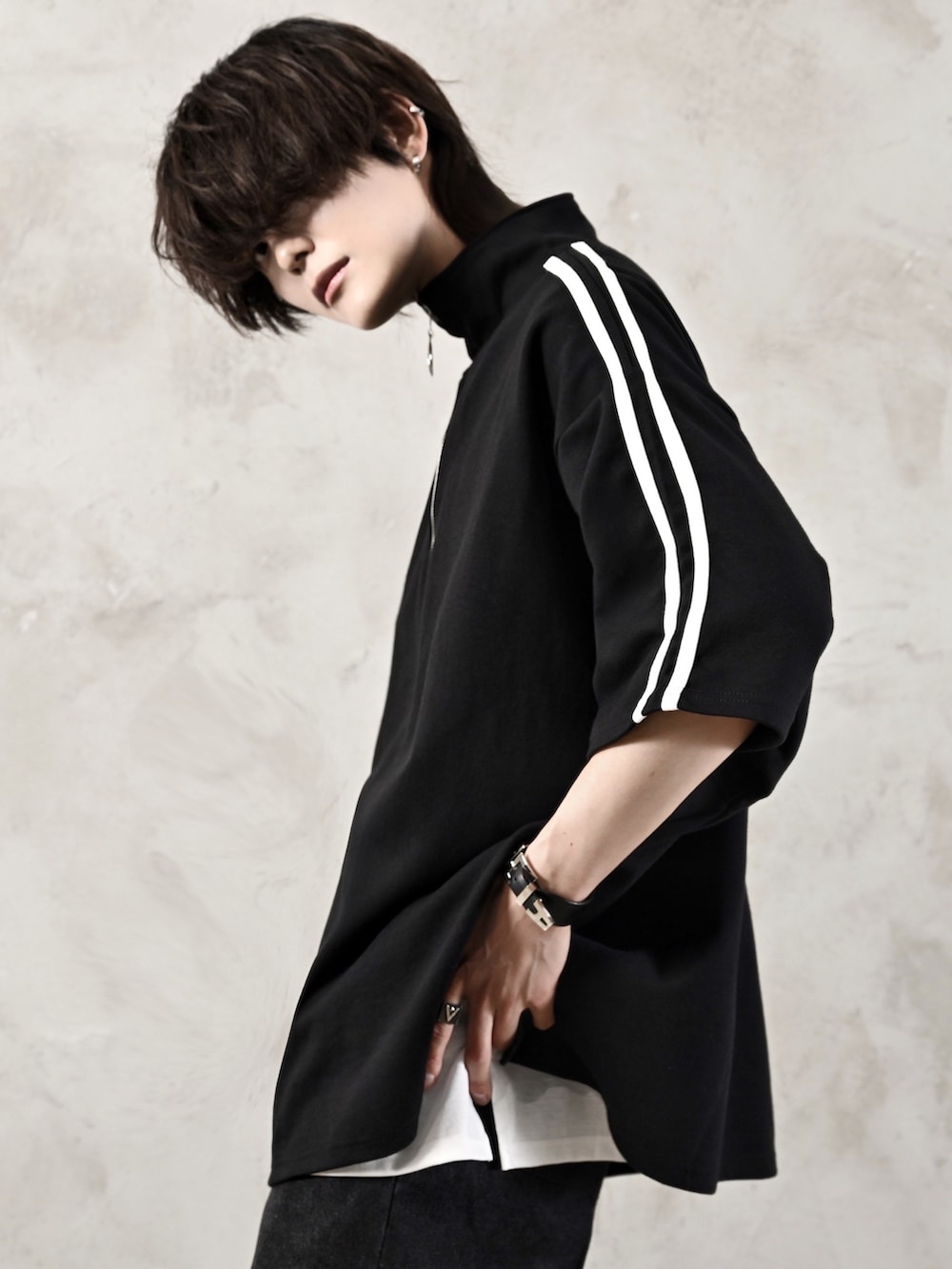 ホワイト系のタンクトップ、ブラック系のブーツ、ブラック系のショルダーバッグを着用したメンズの春コーディネートの3枚目の写真