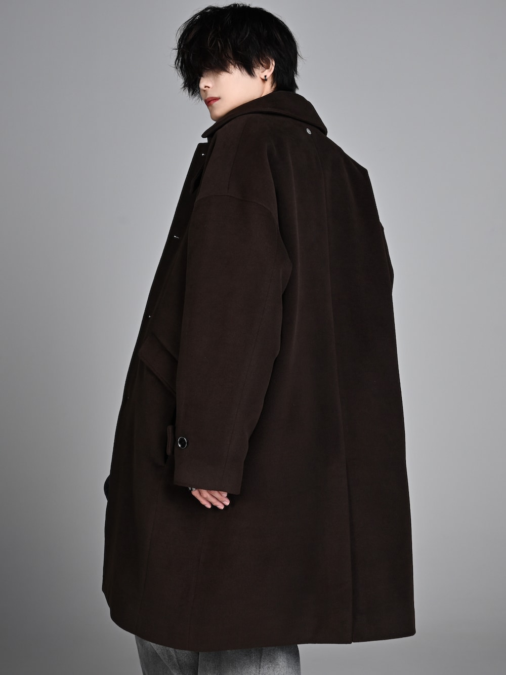 ブラック系のタンクトップ、ブラック系のブーツ、ブラウン系のステンカラーコートを着用したメンズの秋コーディネートの4枚目の写真