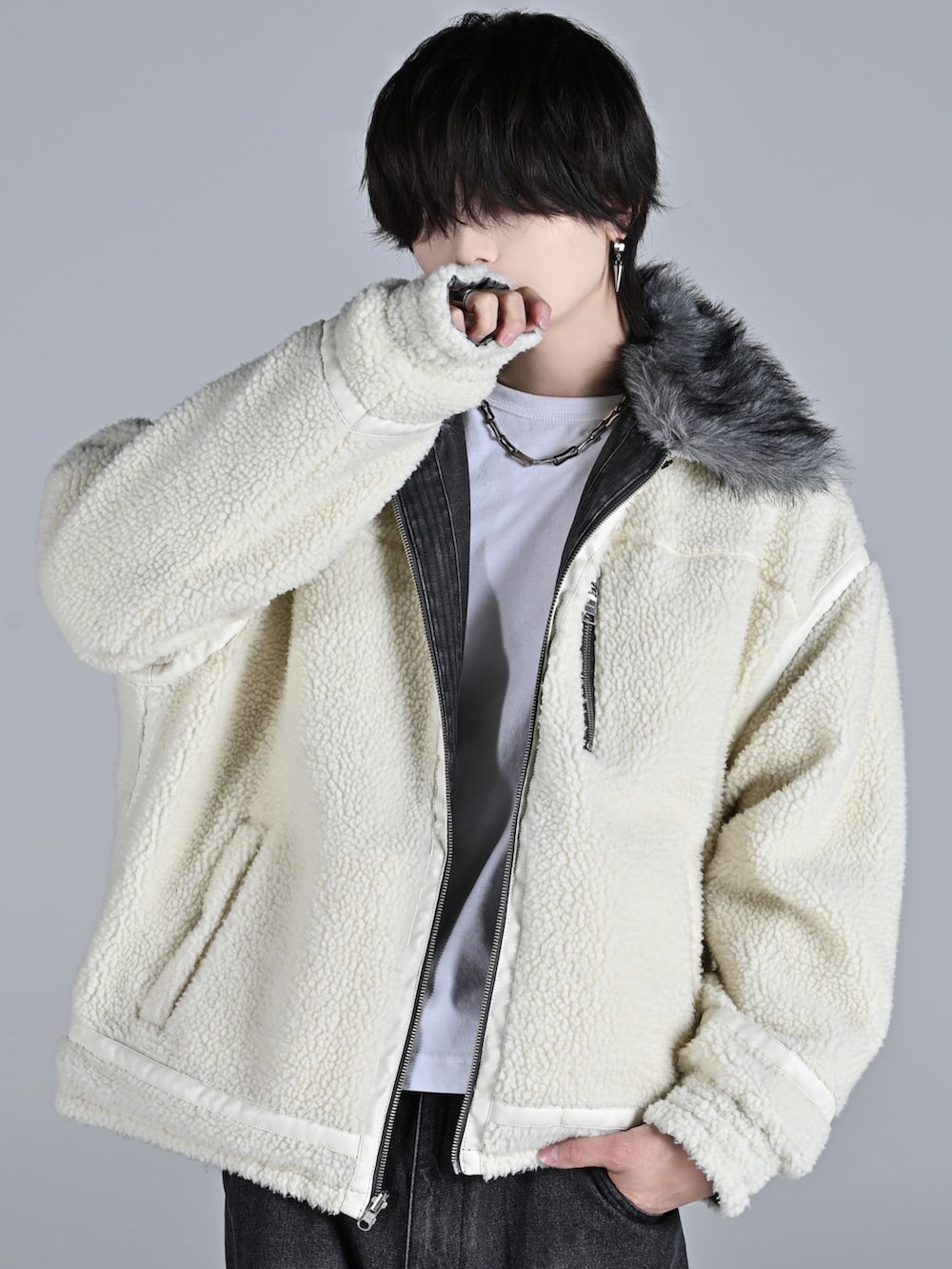 ブラック系のブルゾン、ブラック系のデニムパンツ、ホワイト系のスニーカーを着用したメンズの秋コーディネートの3枚目の写真