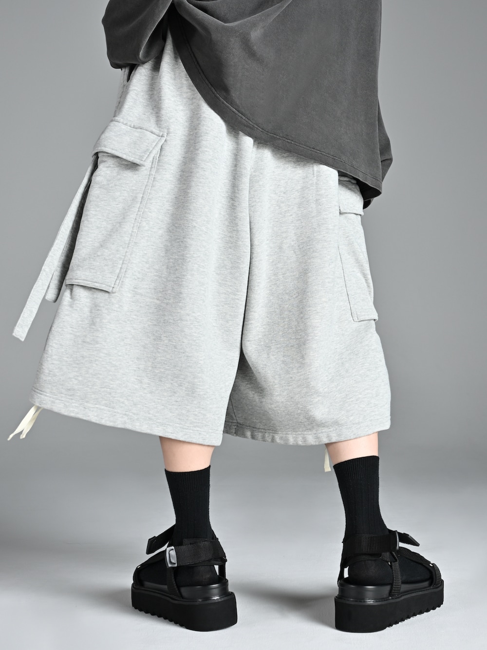 グレー系のTシャツ/カットソー、ブラック系のサンダル、グレー系のカーゴパンツを着用したメンズの夏コーディネートの4枚目の写真